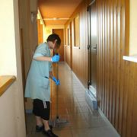Femme nettoyant le sol dans un couloir